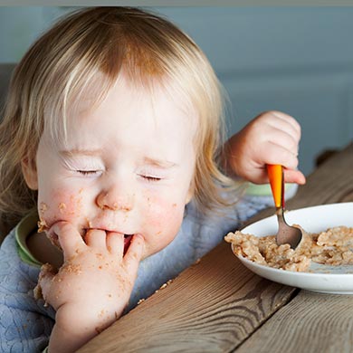 Kind ißt mit Besteck